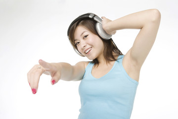 Fototapeta na wymiar Smiling young woman listening to music on headphones