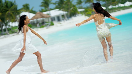 African American Asian Chinese girls laughing together on beach 