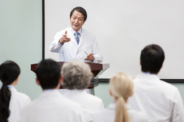 Senior doctor giving speech in boardroom