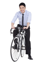 Cool young businessman riding a bike