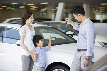 Young family buying car in showroom