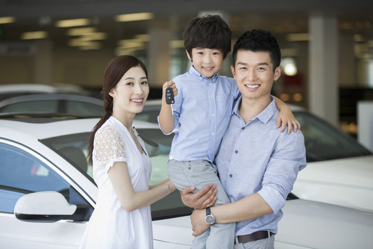Young family buying car in showroom