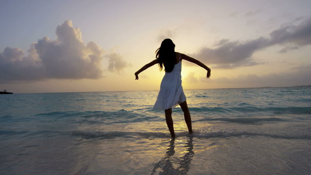 Tropical island Asian Chinese girl at sunrise barefoot on beach