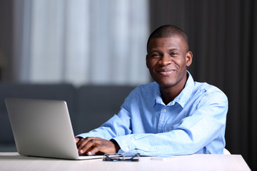 African American businessman in blue shirt with laptop, close up