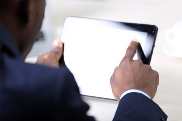 Handsome businessman with tablet in his office, backside view. Close up