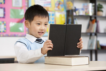 Young student reading in classroom