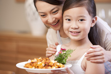 Mother and daughter with a plate of Kung Pao Chicken, Chinese dish