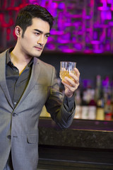 Young man having a drink at bar