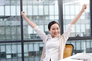 Businesswoman with arms raised in celebration