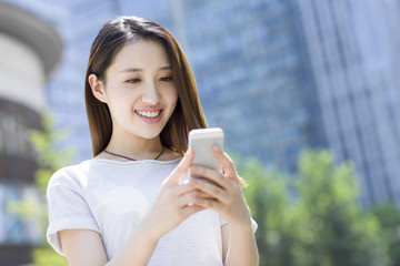 Happy young woman using smart phone