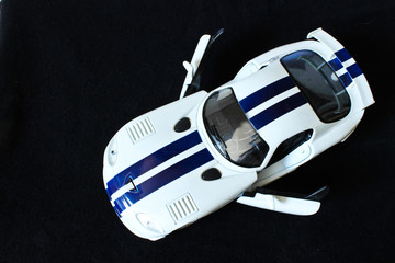Fototapeta premium White Toy Car on the Black Background