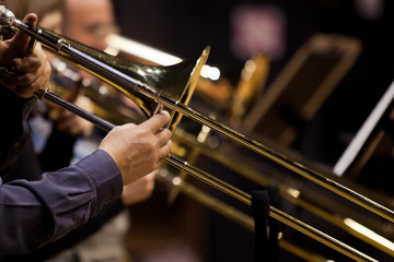 Hands of man playing the trombone in the orchestra