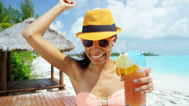 African American girl in bikini and sunglasses on beach with party cocktail