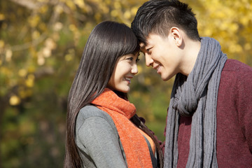 Fototapeta premium Sweet young couple in love face to face outdoors in autumn