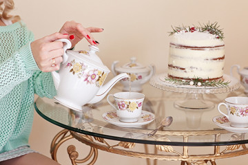 Vintage porcelain tea service with marble winter cake and on glass vintage table. 