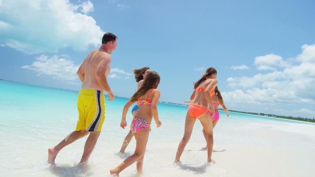 Loving Caucasian family in swimwear on a tropical beach vacation 