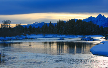Snake River at twilight below the Grand Teton mountain range peaks in the Central Rocky mountains in Grand Tetons National Park in Wyoming USA near the town of Jackson during the winter