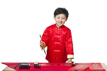 Happy boy writing calligraphy on couplets