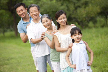 Happy family standing in a row outdoors