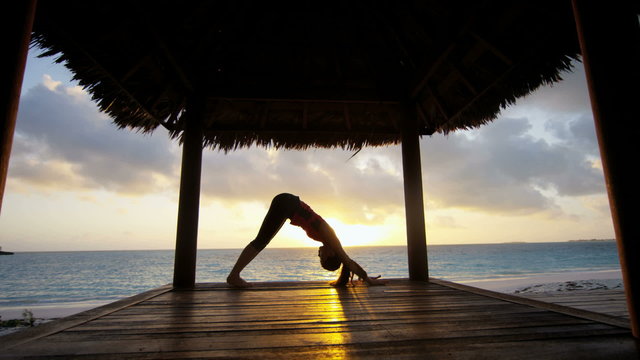 Young girl practicing yoga outdoors at sunrise
