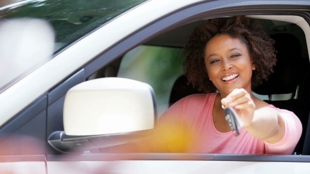 Portrait of happy confident African American female driving new car