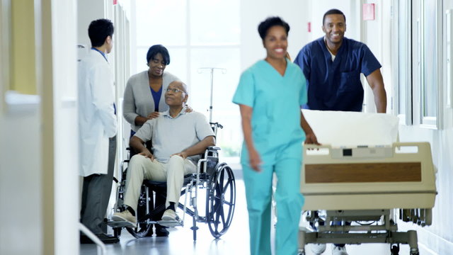 African American disabled male on wheelchair and wife in medical center
