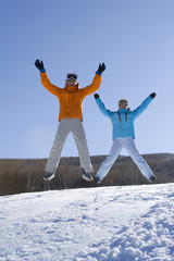 Two young women jumping into the air