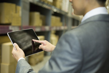 Businessman using digital tablet in warehouse