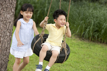 Excited children playing on a swing