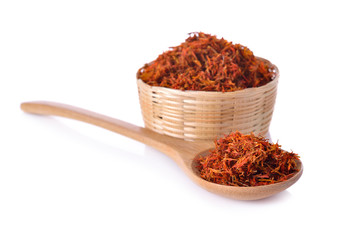 dried safflower in basket and spoon on white background