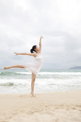 Fototapeta na wymiar A woman dancing at the beach