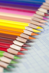 Fototapeta premium Color pencils in a neat row on blueprint