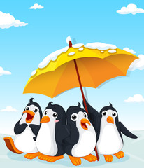 Penguins standing under umbrella
