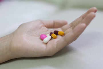 Closeup shot of a woman showing capsule pill. Female hand holdin