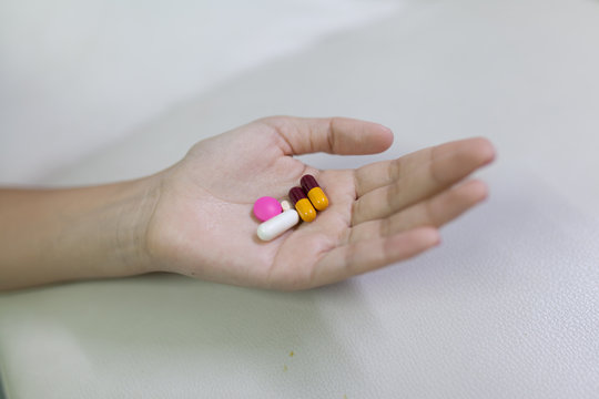 Closeup shot of a woman showing capsule pill. Female hand holdin