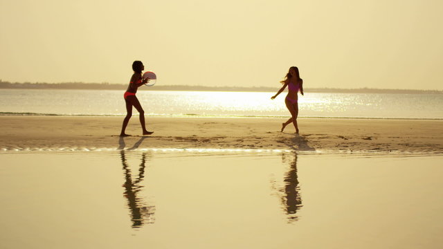 African American Asian Chinese girls on beach at sunrise