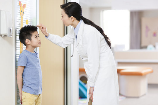 Doctor measuring boy's height