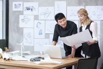  Designers studying blueprint in studio