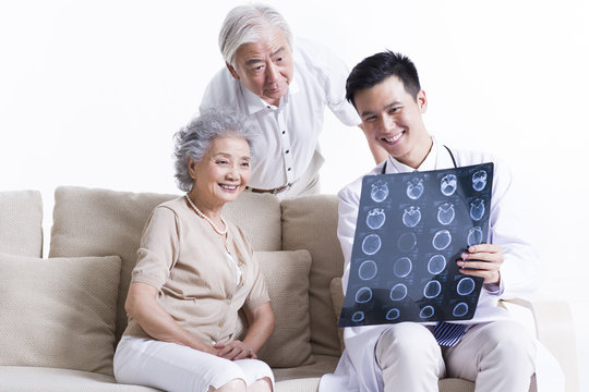 Doctor explaining X-ray image to senior couple