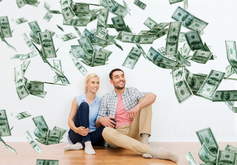 happy couple at home over dollar money falling