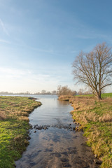 Fototapeta na wymiar Narrow stream flows into a large river