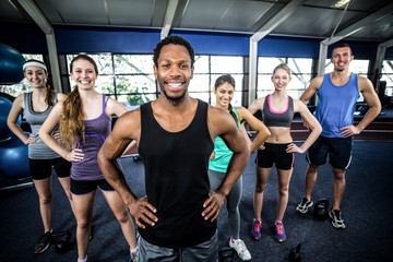 Fototapeta premium Smiling fitness class posing together with hands on hips