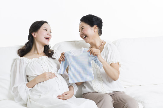 Mother and daughter preparing baby clothing