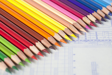 Obraz premium Color pencils in a neat row on blueprint