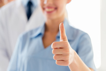 close up of doctor or nurse showing thumbs 