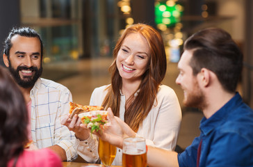 friends eating pizza with beer at restaurant