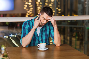 man with smartphone and coffee at restaurant