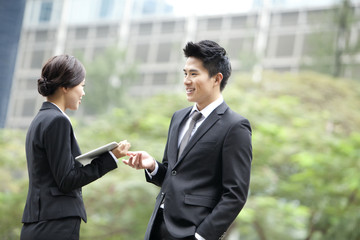 Cheerful business colleagues chatting with digital tablet in hand, Hong Kong