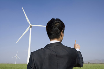 Businessman in front of wind turbine