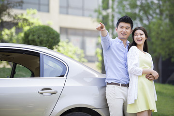 Happy young couple and car